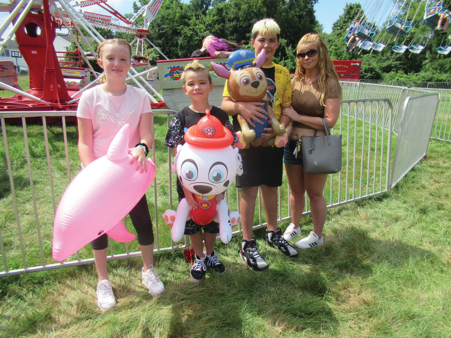 POPULAR PRIZES: Isabella Corentos, Lorenzo Corentos and Nicholas Nardolillo are joined by their mom while showing off the inflated prizes they won at the hammer game.